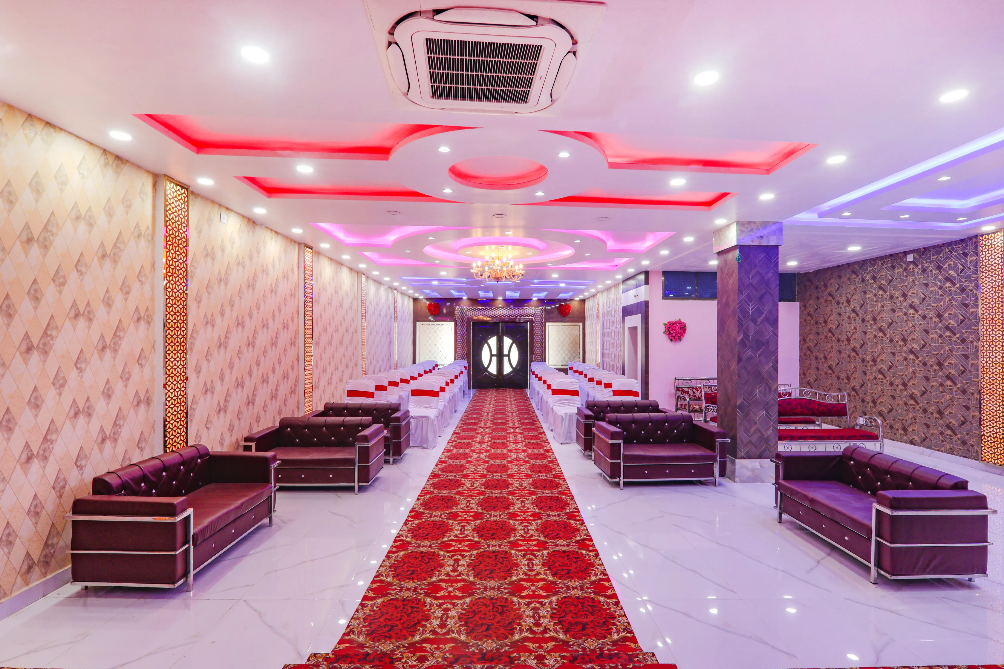 Banquet hall lounge with sofas and red carpet aisle