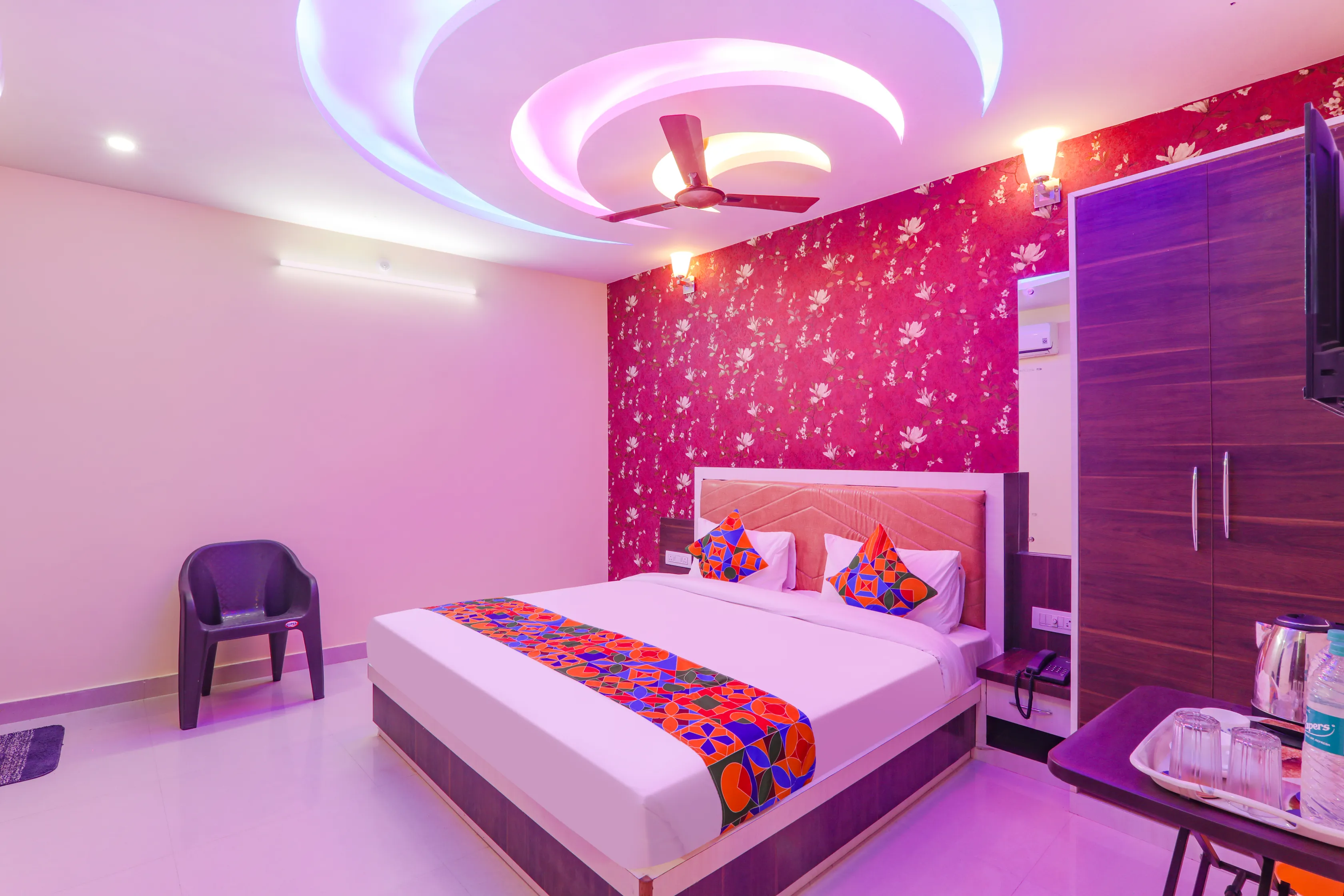 Deluxe double room with pink floral wall at Hotel Nikunj